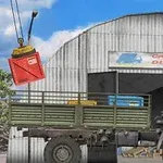 Ciężarówka stoi przed magazynem z szyldem Cargo Delivery, a żuraw przenosi czerwoną skrzynię