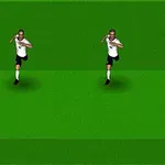 Dwóch piłkarzy w białych koszulkach biegnie w stronę piłkarza w żółtej koszulce na zielonym boisku