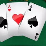 Trzy karty do gry na zielonym stole, asy trefl, kier i pik