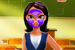 Kobieta o ciemnych włosach z fioletową maseczką na twarzy stoi w klasie na tle zielonej tablicy i drewnianych ławek