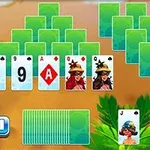 Zielone karty ułożone w piramidę, poniżej odsłonięte karty z liczbami i ilustracjami, obok stos zakrytych kart i karta Jokera