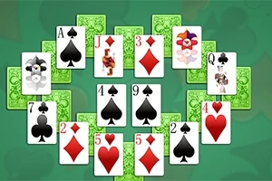 Karty do gry ułożone w półokrąg na zielonym tle, z wyraźnie widocznymi symbolami pików, kierów, treflów i karo