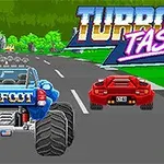 Niebieski monster truck i czerwony sportowy samochód jadące po szarej drodze, z kolorowym napisem Turbo Tastic na zielonym tle