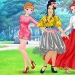 Trzy kobiety w eleganckich strojach pozują w parku